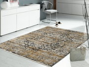 Designer Teppich in einem modernen Wohnzimmer, aus der Perspektive von schräg oben fotografiert, mit einem eleganten, gemusterten Design in Beige- und Grautönen.