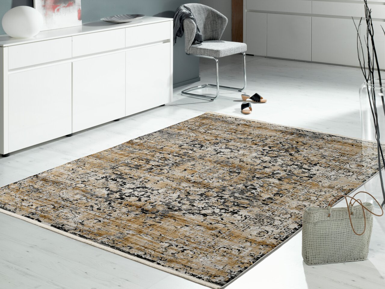 Designer Teppich in einem modernen Wohnzimmer, aus der Perspektive von schräg oben fotografiert, mit einem eleganten, gemusterten Design in Beige- und Grautönen.
