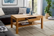 Moderner Couchtisch aus Holz mit Schublade und Ablage, umgeben von einem gemütlichen Wohnzimmer mit Sofa und Pflanzen, aus seitlicher Perspektive.