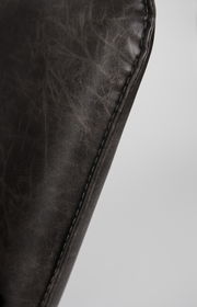 Nahaufnahme der Naht eines Sessels aus dunkelbraunem Leder, seitliche Perspektive