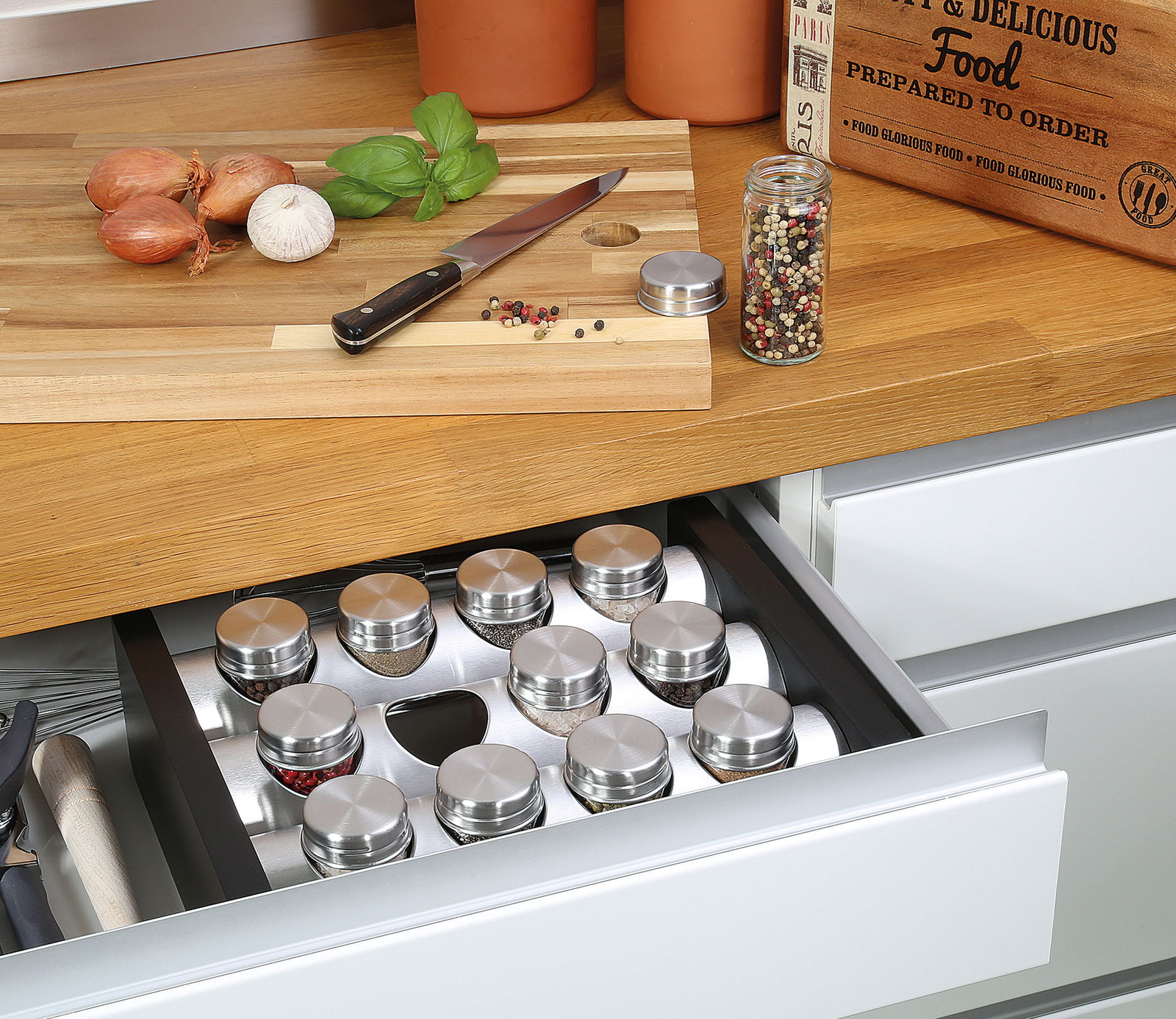 Gewürzständer mit 12 Gläsern in einer geöffneten Küchenschublade, von oben fotografiert.
