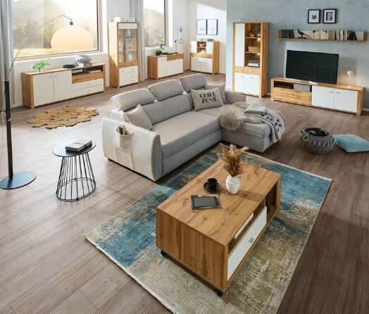 Een moderne wandmeubel in een stijlvolle woonkamer met houten meubels en een grijze bank, gezien vanuit vogelperspectief.