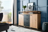 Modernes Sideboard aus Holz mit drei Schubladen und zwei Türen, dekoriert mit Pflanzen und Bildern, seitliche Perspektive.