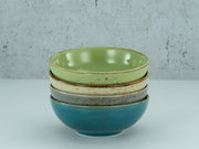 Stapel von vier Smoothie-Schalen in verschiedenen Farben, von oben nach unten: grün, beige, grau und blau, seitliche Perspektive