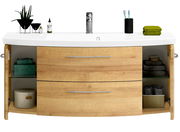Frontale Ansicht eines modernen Waschtischs mit Holzoptik, zwei Schubladen und offenen Seitentüren, dekoriert mit Pflanzen, Handtüchern und Pflegeprodukten.