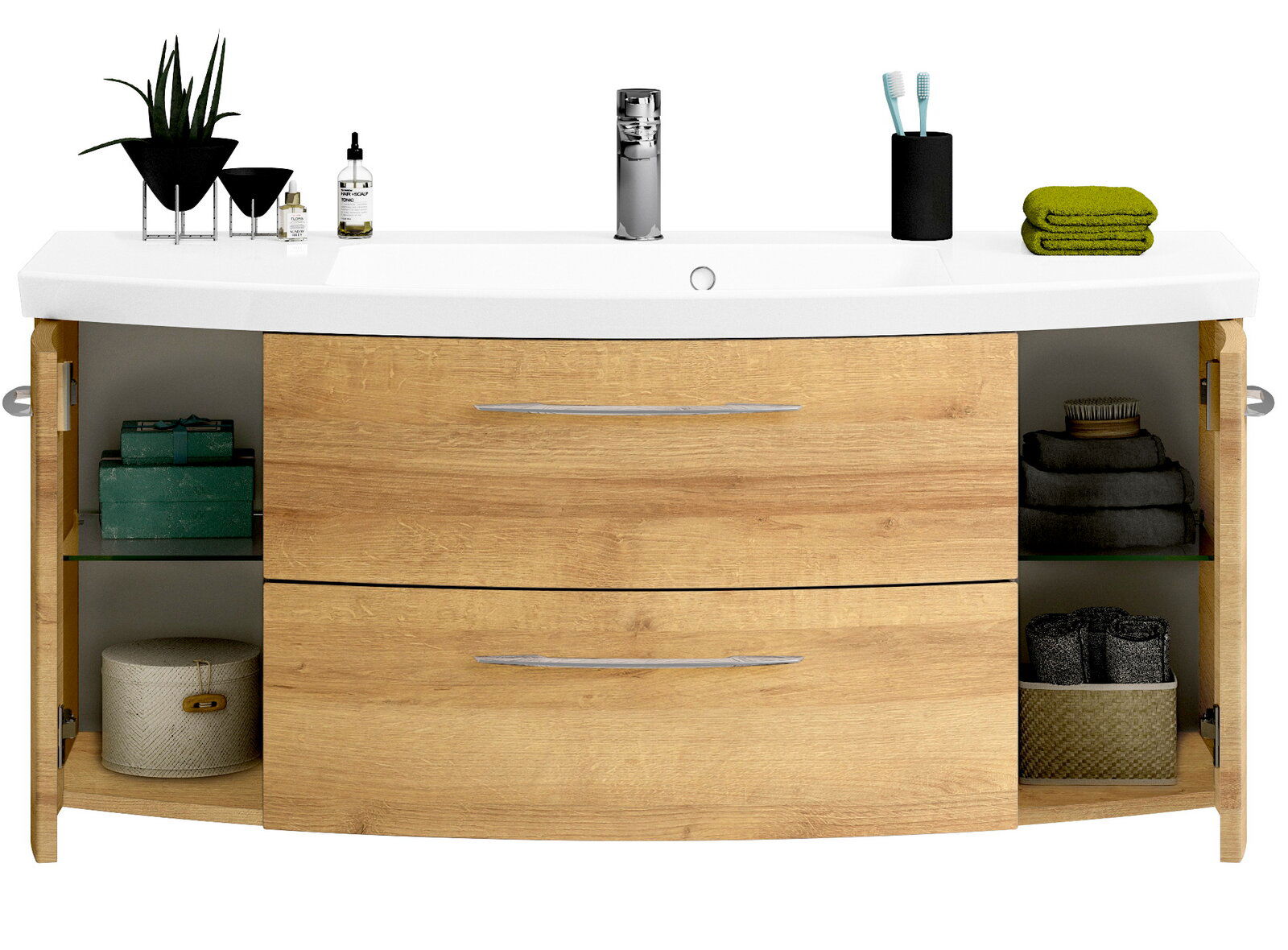 Frontale Ansicht eines modernen Waschtischs mit Holzoptik, zwei Schubladen und offenen Seitentüren, dekoriert mit Pflanzen, Handtüchern und Pflegeprodukten.