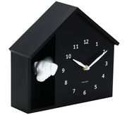 Schwarze Wanduhr in Form eines Hauses mit einem weißen Hundekopf, seitliche Perspektive
