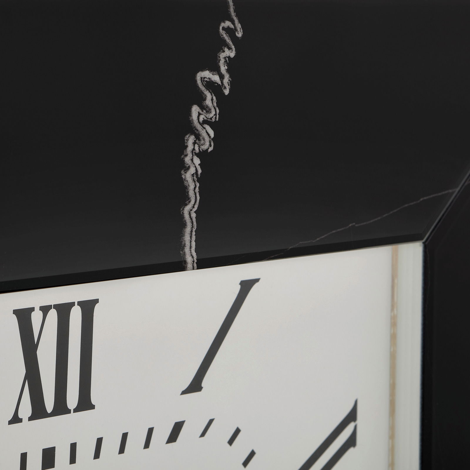 Nahaufnahme einer Wanduhr mit römischen Ziffern und einem schwarzen Rahmen, aus seitlicher Perspektive.