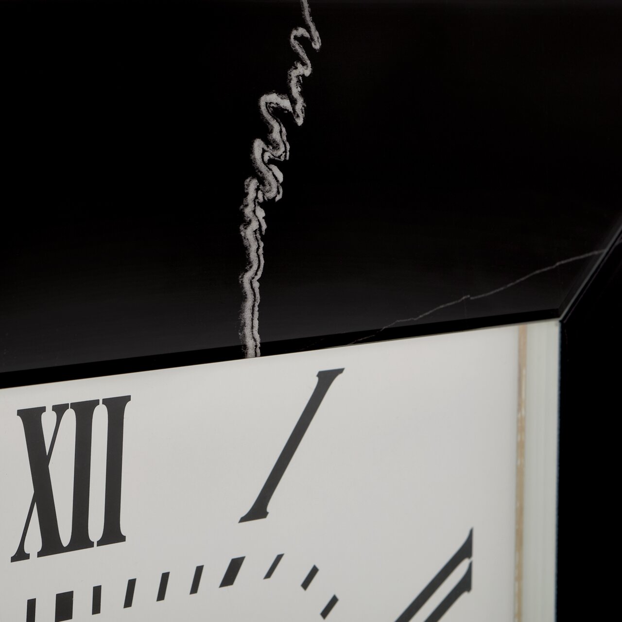 Nahaufnahme einer Wanduhr mit römischen Ziffern und einem schwarzen Rahmen, aus seitlicher Perspektive.