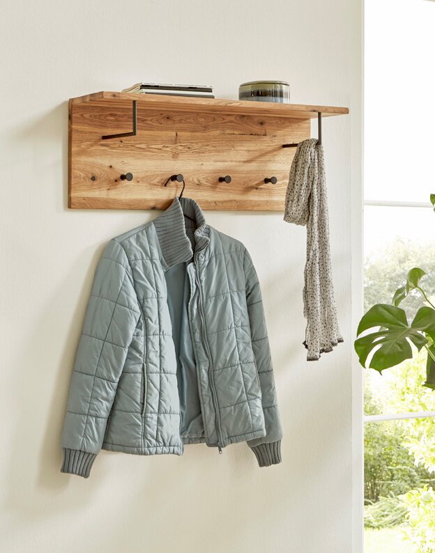 Zurbrüggen Wandgarderobe Wandgarderobe aus massivem Holz mit Ablage und mehreren schwarzen Haken, an der eine hellblaue Jacke und ein Schal hängen; seitliche Perspektive im hellen Eingangsbereich