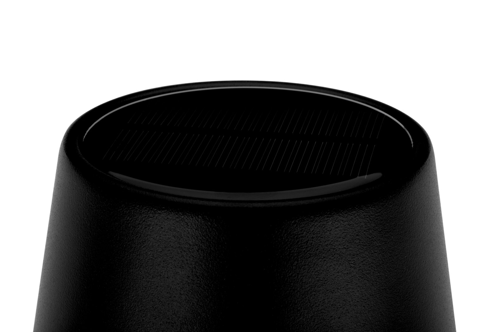 Close-up van een zwarte zonne-lamp van bovenaf, waarbij het zonnepaneel te zien is.