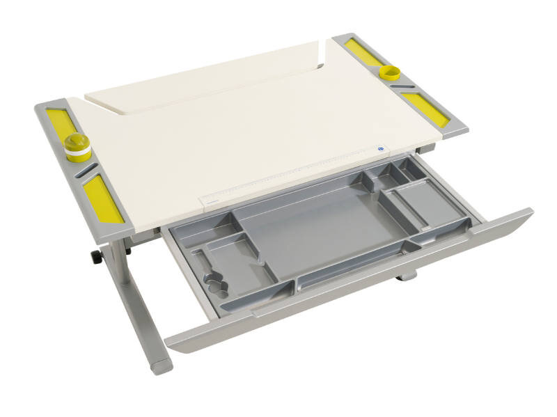 Schubkasten mit mehreren Fächern und gelben Akzenten, von oben betrachtet.