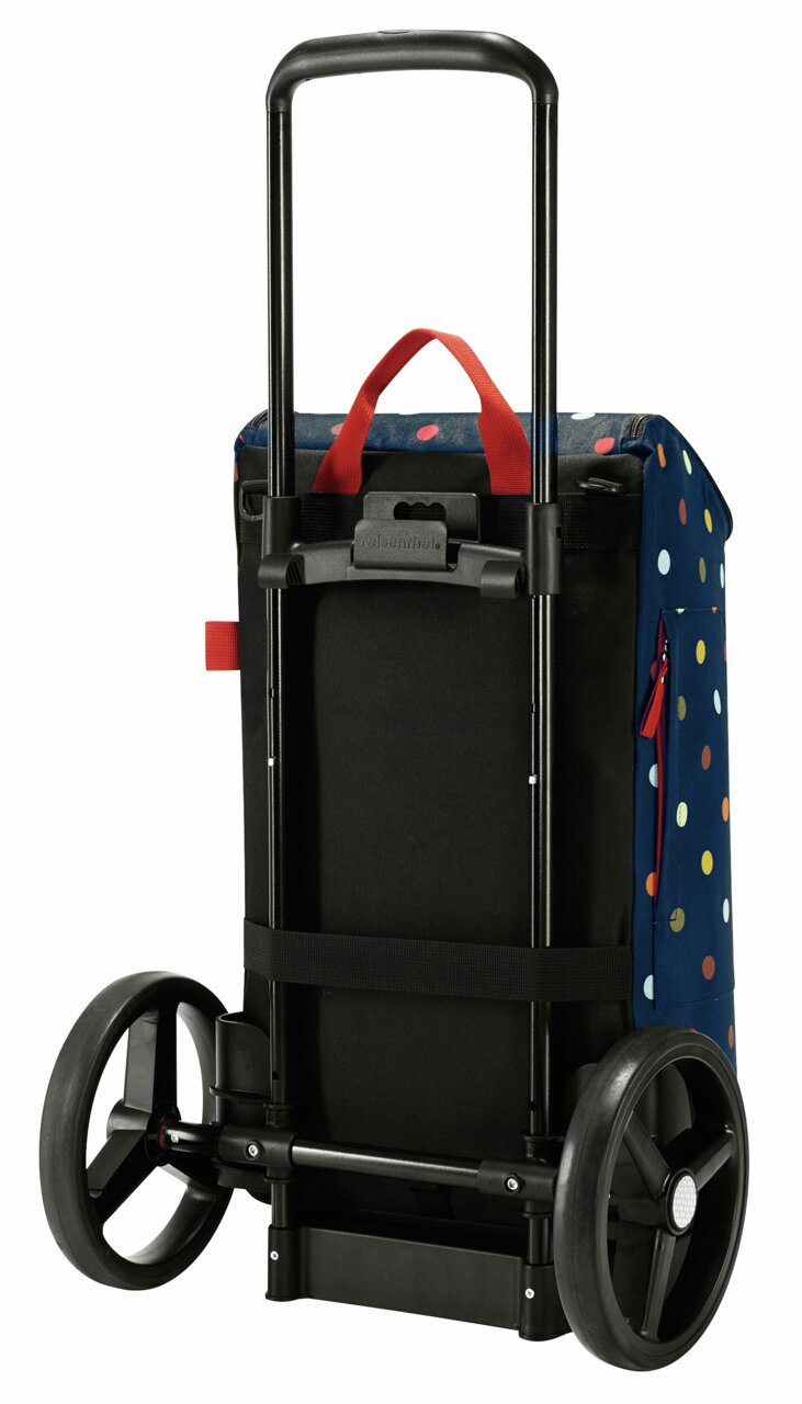 Rückansicht einer Citycruiser-Tasche mit buntem Punktmuster und rotem Griff, montiert auf einem schwarzen Rollgestell mit großen Rädern.
