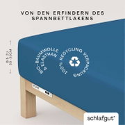 Blaues Spannbettlaken aus Bio-Baumwolle und Elasthan, geeignet für Matratzen bis zu 30-35 cm Höhe, mit Recycling-Verpackung, seitliche Perspektive.
