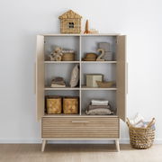 Moderner Kleiderschrank mit zwei offenen Türen, gefüllt mit Körben und Dekorationen, aus frontaler Perspektive.