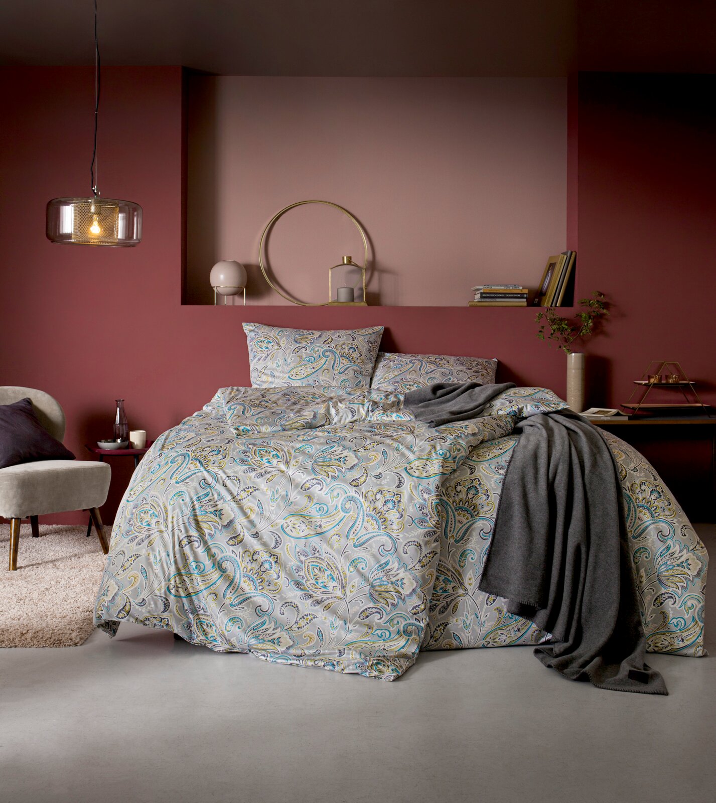Beddengoedset in een stijlvolle slaapkamer met bloemmotieven in zachte kleuren, gefotografeerd van voren.