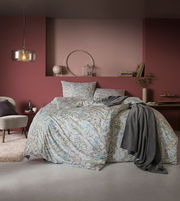 Bettwäsche-Set in einem stilvollen Schlafzimmer mit floralen Mustern in sanften Farben, frontal aufgenommen.