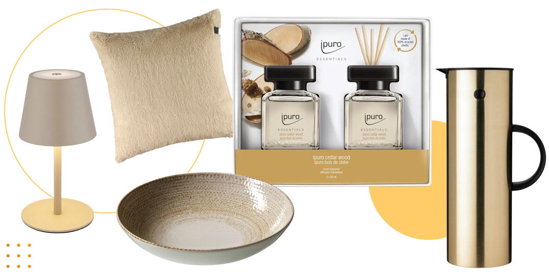 Tischlampe, Kissen, Duftset, Keramikschale und goldene Thermoskanne als Wohnaccessoires.