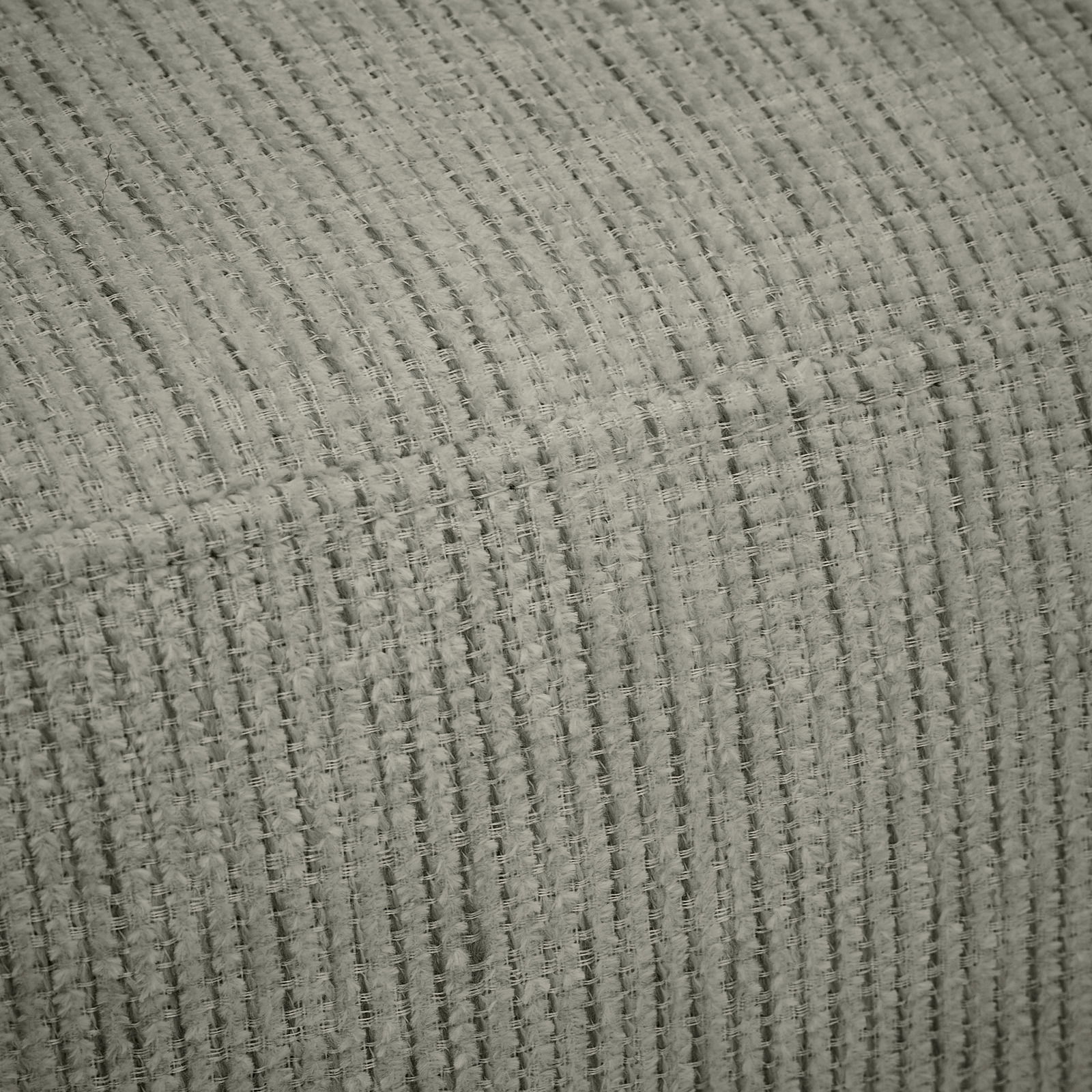 Nahaufnahme eines strukturierten, grauen Stoffes mit parallelen Linien, perspektivisch von der Seite aufgenommen.