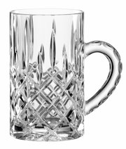 Transparante glazen bierpul met decoratief geslepen ruit- en puntmotief, van voren en licht van bovenaf gezien, met het handvat rechts.