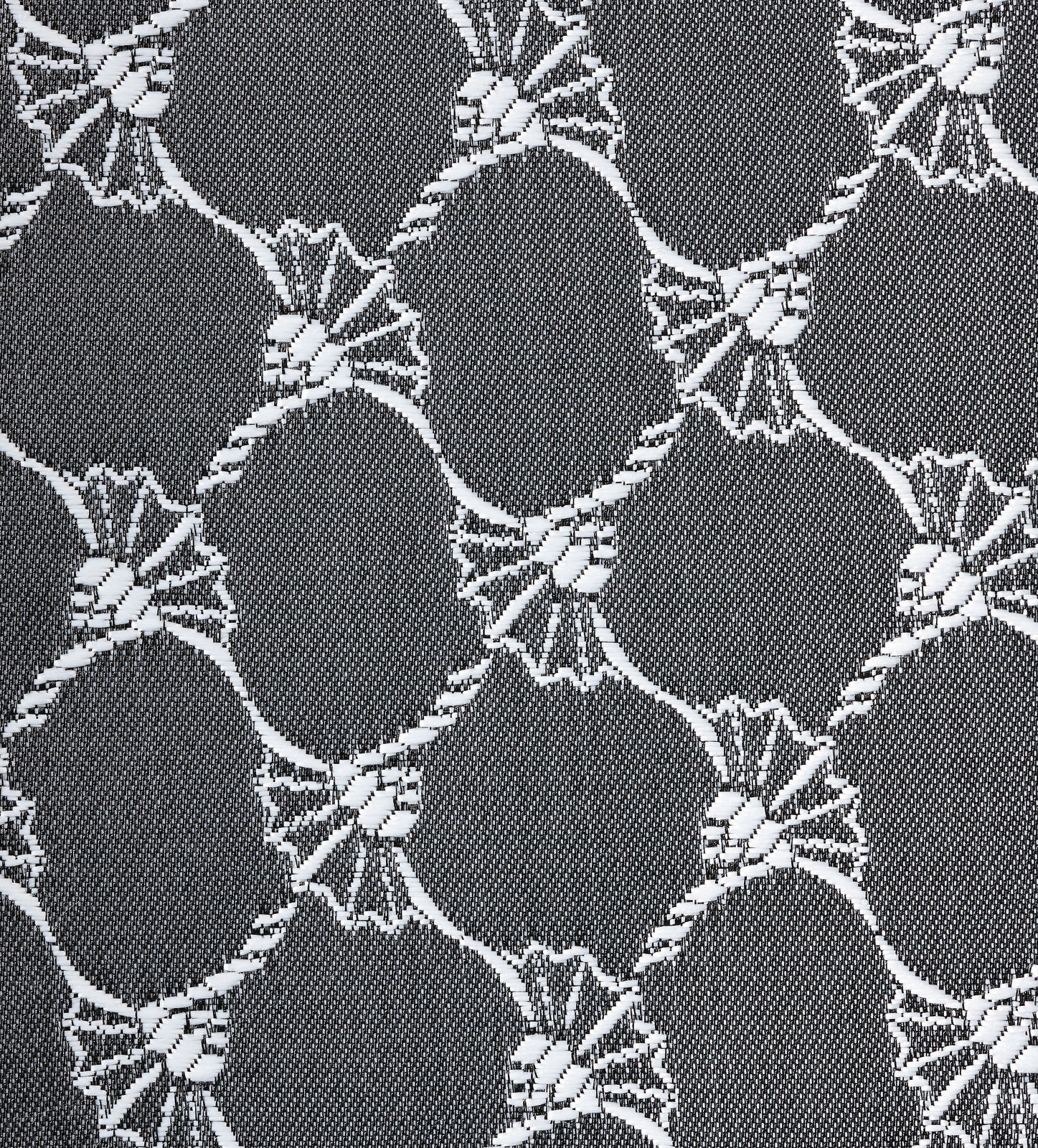 Nahaufnahme eines grauen Ösenvorhangs mit weißem, kreisförmigem Muster.