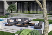 Moderne buitenlounge met grijze zitmeubelen en salontafels op een terras, omgeven door een groen landschap. Aanzicht van schuin bovenaf.