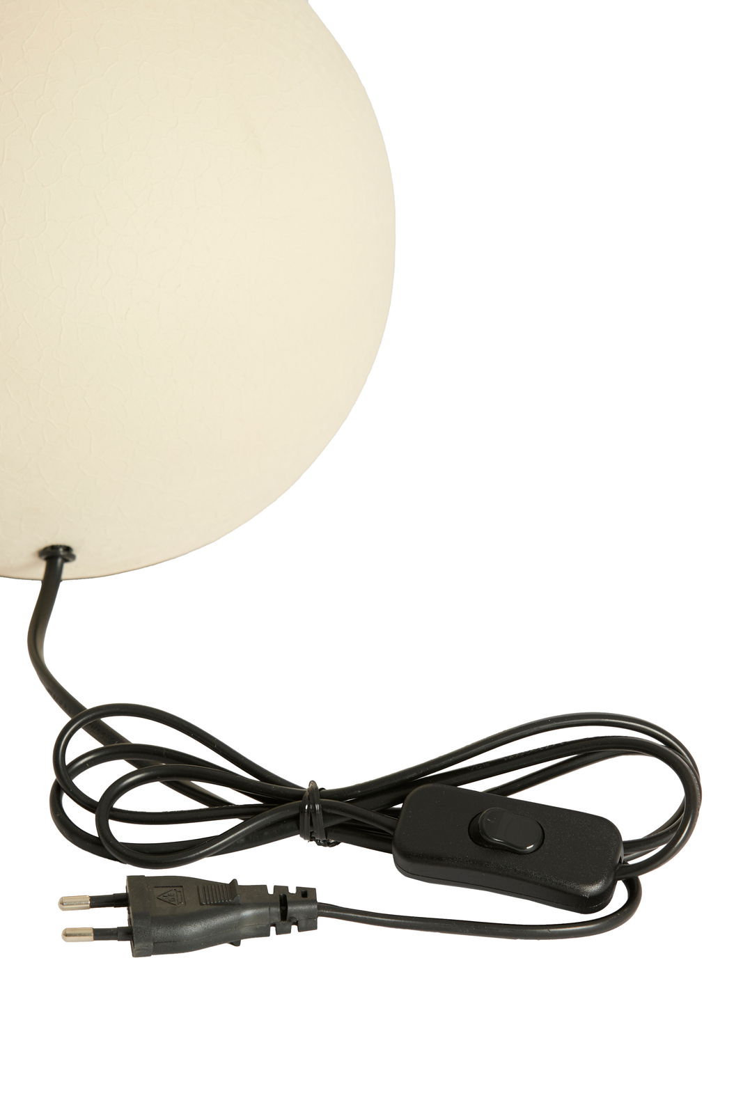 Nahaufnahme eines weißen Lampenfußes mit schwarzem Kabel und Schalter, seitliche Perspektive