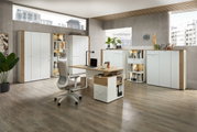 Moderne Büromöbel in einem hellen Raum mit Schreibtisch, Bürostuhl und mehreren Schränken, seitliche Perspektive