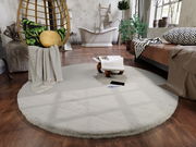 Runder Fellteppich in einem modernen Wohnzimmer mit hängendem Stuhl, Pflanzen und Badewanne im Hintergrund, aus der Vogelperspektive betrachtet.