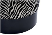 Detailfoto in schuin zijaanzicht van een ronde poef met stof met zwart-wit zebraprint en een matzwarte voet