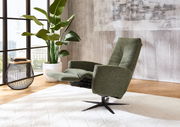 Grüner Relax-Sessel in einem modernen Wohnzimmer, seitliche Perspektive, neben einem großen Fenster und einer Pflanze.