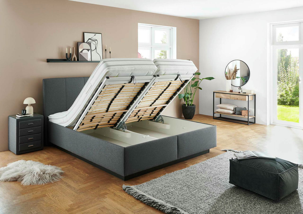 Graues Polsterbett mit hochgeklapptem Lattenrost, seitliche Perspektive, modernes Schlafzimmerdesign.