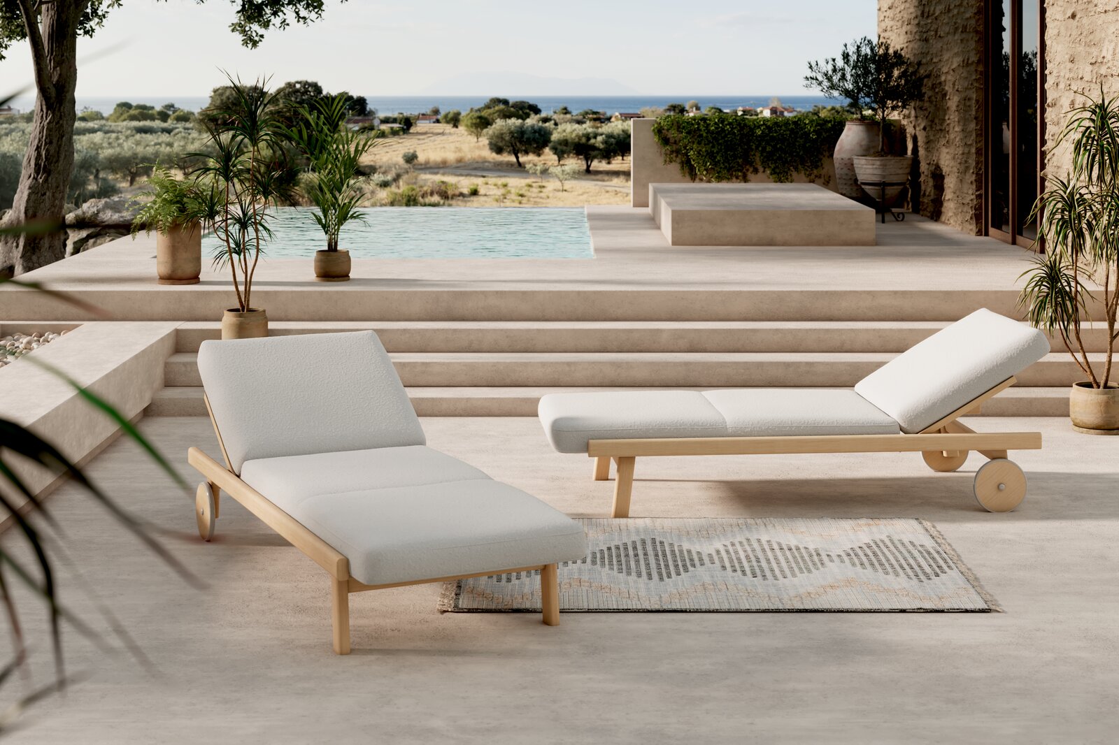 Zwei moderne Sonnenliegen mit Holzrahmen und weißen Polstern auf einer Terrasse mit Blick auf einen Pool und eine Landschaft im Hintergrund, seitliche Perspektive.