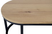 Nahaufnahme eines Couchtischs mit runder Holzplatte und schwarzem Metallgestell, von oben betrachtet.
