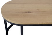 Close-up van een salontafel met een rond houten blad en een zwart metalen onderstel, gezien van bovenaf.