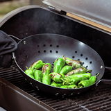 BBQ Wokpfanne mit gegrillten grünen Paprikaschoten auf einem Grill, seitliche Perspektive