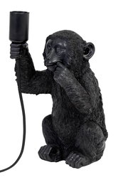 Schwarze Tischleuchte in Form eines sitzenden Affen, der eine Lampenfassung in der Hand hält. Frontalansicht.