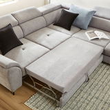 Ecksofa MAROLA in hellgrauem Stoff mit ausziehbarer Liegefläche, zwei schwarzen und einem blauen Kissen, aus der Vogelperspektive fotografiert.