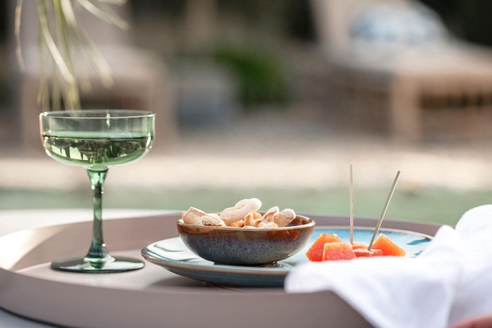 Grüne Sekt- und Dessertschale auf einem Tablett im Freien, seitliche Perspektive