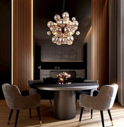 Moderne Hängeleuchte mit kugelförmigem Design über einem Esstisch, seitliche Perspektive.