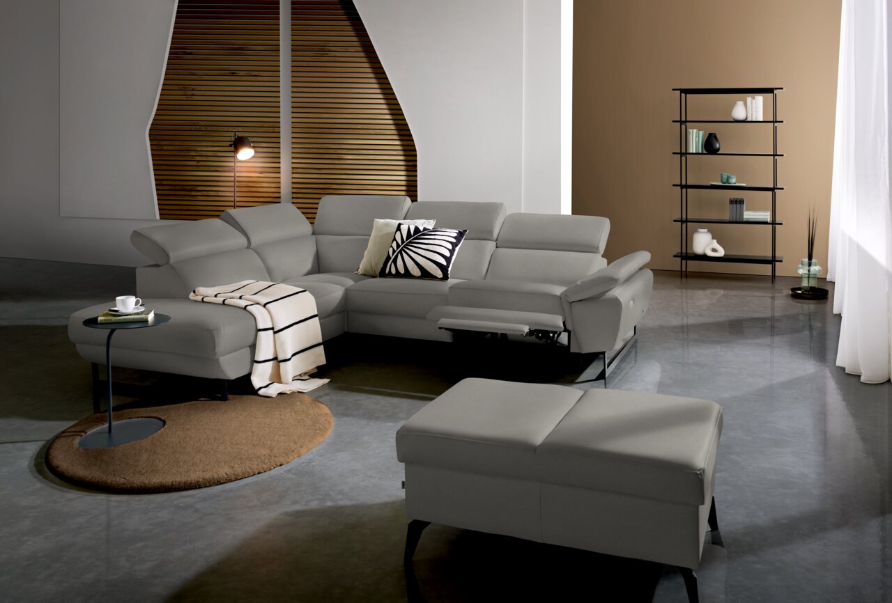 Grauer Hocker in einem modernen Wohnzimmer, Perspektive von vorne.