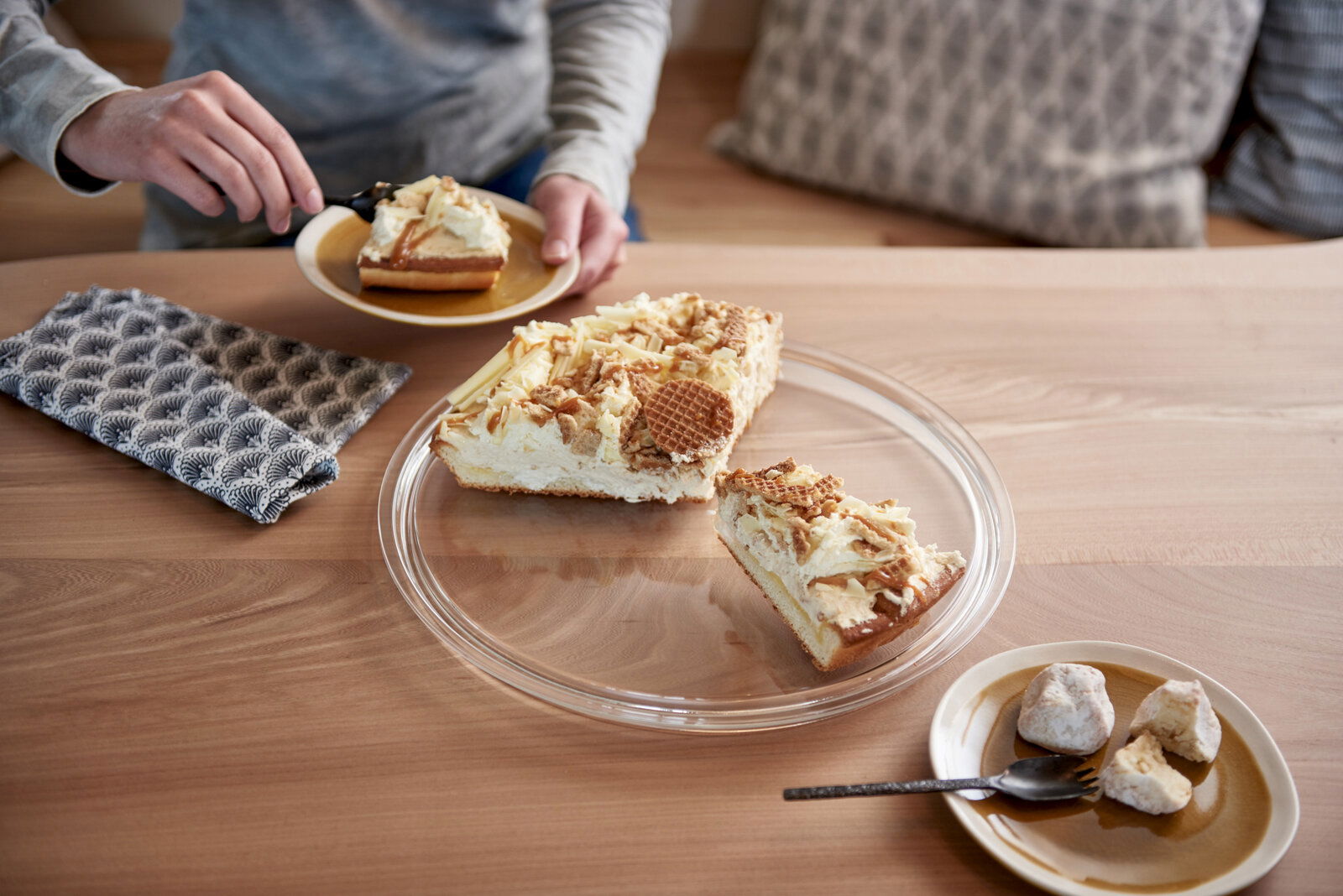 Tortenplatte Ciao mit Kuchenstücken, von oben fotografiert, auf einem Holztisch.