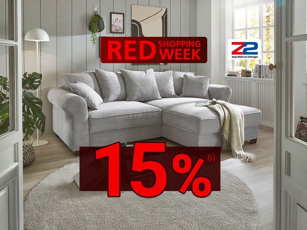 Helles Wohnzimmer mit grauem Ecksofa, Rundteppich, Wandbildern, Tageslicht und rotem „Red Shopping Week“-Banner
