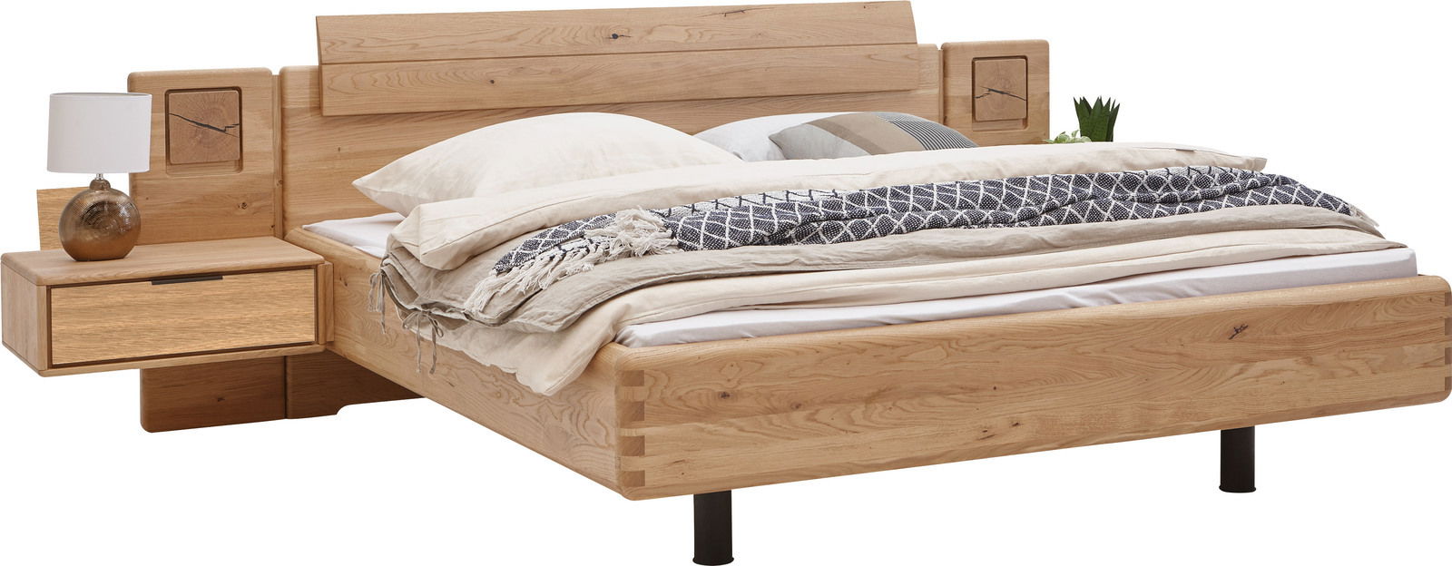 Holzbettgestell mit integrierten Nachttischen, dekoriert mit Kissen und Decken, aus seitlicher Perspektive