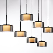 Moderne Pendelleuchte RIKA mit mehreren zylindrischen, rauchgrauen Glasschirmen, die von der Decke hängen. Seitenansicht.