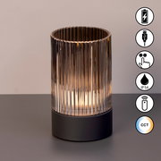 Akku-Windlicht mit geriffeltem Glas und schwarzem Sockel, seitliche Ansicht, Symbole für USB-Ladung, Touch-Bedienung, IP54-Schutz, Fernbedienung und CCT-Farbtemperatur.