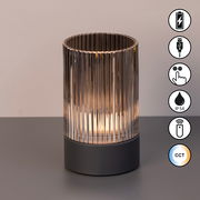 Akku-Windlicht mit geriffeltem Glas und schwarzem Sockel, seitliche Ansicht, Symbole für USB-Ladung, Touch-Bedienung, IP54-Schutz, Fernbedienung und CCT-Farbtemperatur.