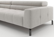 Lichtgrijze, gewatteerde bank met ribstof bekleding en zwarte metalen poten, getoond in schuin vooraanzicht met focus op armleuning en zitkussens.
