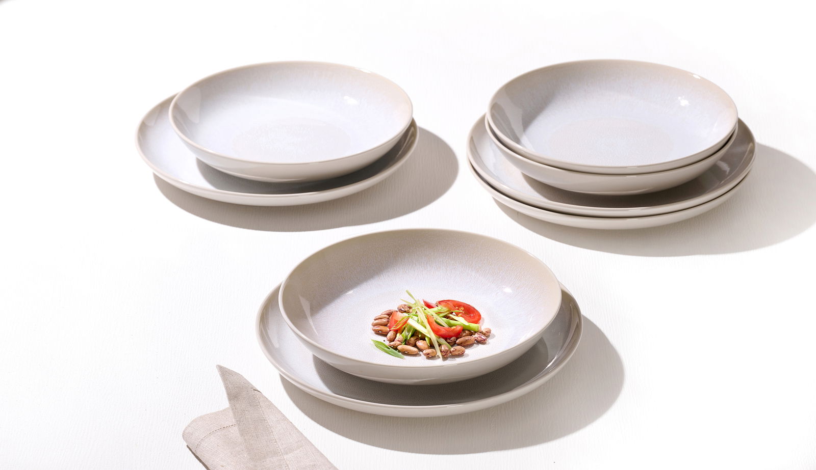 Frühstücksset Laredo 12-tlg. aus der Vogelperspektive, bestehend aus mehreren gestapelten Tellern und einer Schale mit Bohnen, Tomaten und Frühlingszwiebeln.