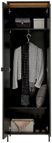 Garderobenschrank in schwarzer Farbe, frontal geöffnet, mit mehreren Fächern. Oben eine Handtasche und eine Box, in der Mitte ein grauer Blazer mit Schal, unten ein Kissen und ein Paar Schuhe.